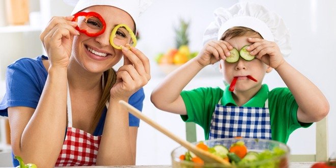 Happy cute family have fun in the kitchen with vegetables Family have fun in the kitchen with vegetables