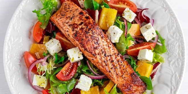 Fried Salmon steak with fresh vegetables salad, feta cheese. concept healthy food. healthy diet
