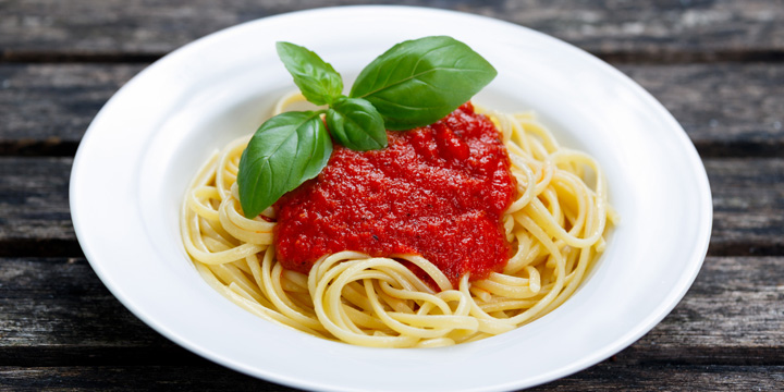 Spaghetti with marinara sauce and basil leaves on top marinara sauce