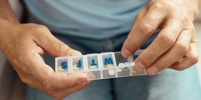 Nice aged man opening a pill container reverse diabetes - take medication