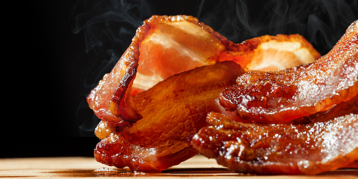 Hot Bacon With Steam Isolated on Black processed meat