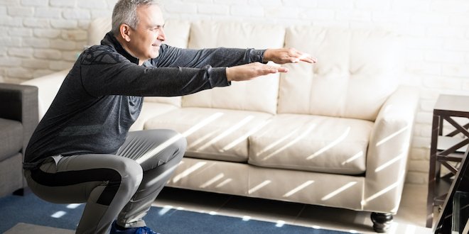 Mature man doing squats workout at home prediabetes exercise