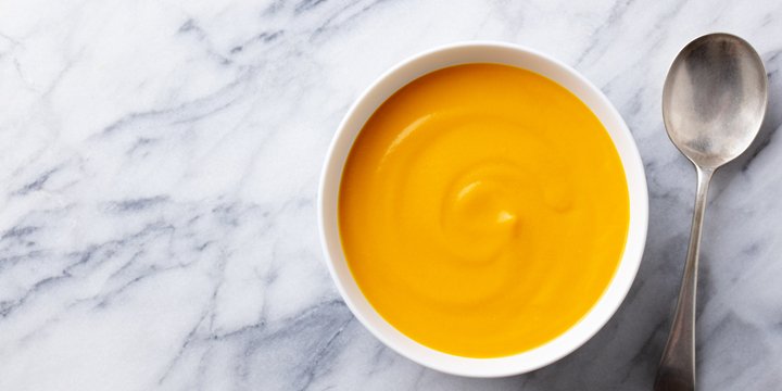 Healthy comfort pumpkin, butternut squash soup in white bowl. Marble background. Copy space. Top view. butternut squash