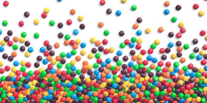 Colorful coated chocolate candies scattered on white background candy
