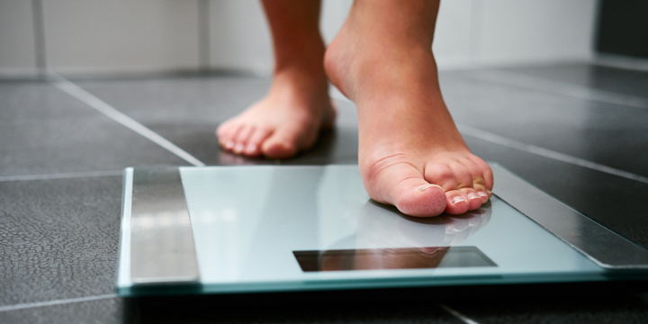 Female bare feet with weight scale