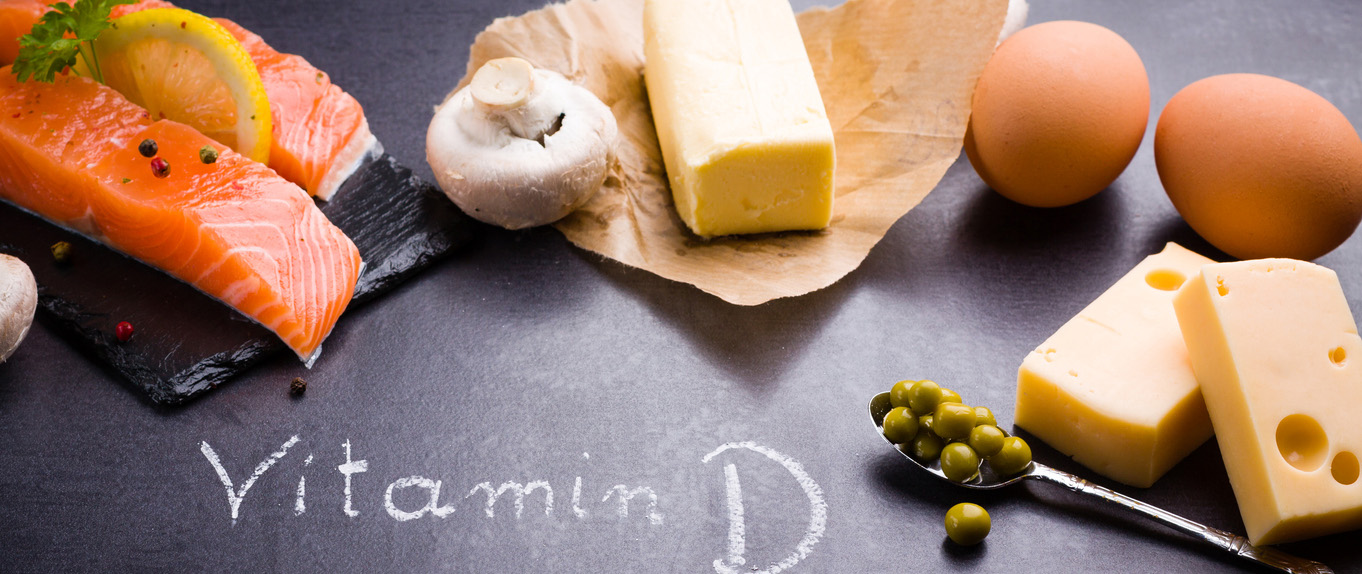 Black slate table with product rich in vitamin D and omega 3. Written word vitamin D by white chalk.