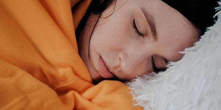 Girl has fever. Young attractive Caucasian woman lies on bed of her shakes. Cold, flu, cold sweat, virus, acute respiratory illness, chills concept