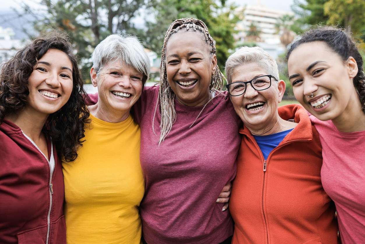 Happy multi generational women having fun together - Multiracial friends smiling on camera after sport workout outdoor - Main focus on african female face Happy multi generational