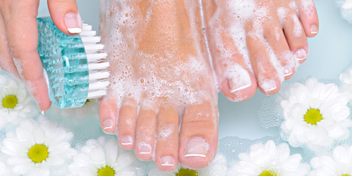 Woman washes and cleans her foot