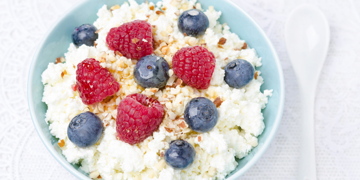 bowl of cottage cheese with berries, honey and nuts
