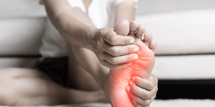 Asian woman feeling pain in her foot at home