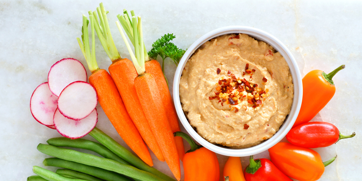 Hummus with fresh vegetables, above view on white marble best bedtime snacks