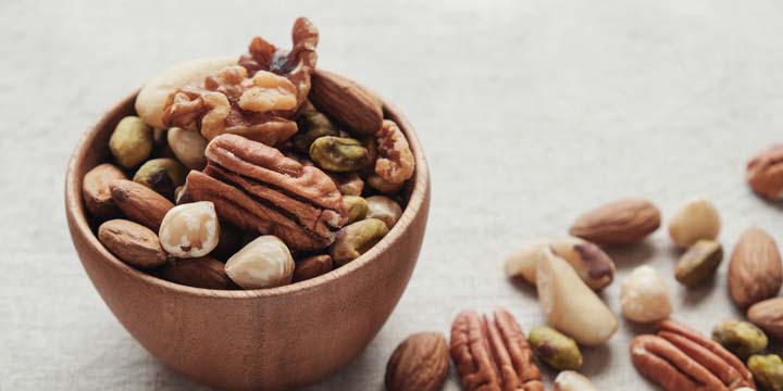 mixed nuts in wooden bowl, healthy fat and protein food and snack, ketogenic diet food