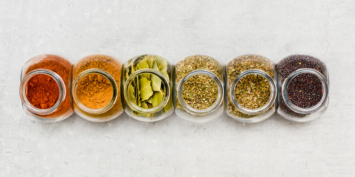 A selection of herbs and spices for adding flavour to food when cooking on a kitchen worktop at high angle