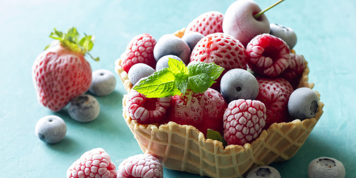 Frozen summer fruits with mint leaf served in waffle bowl frozen fruit