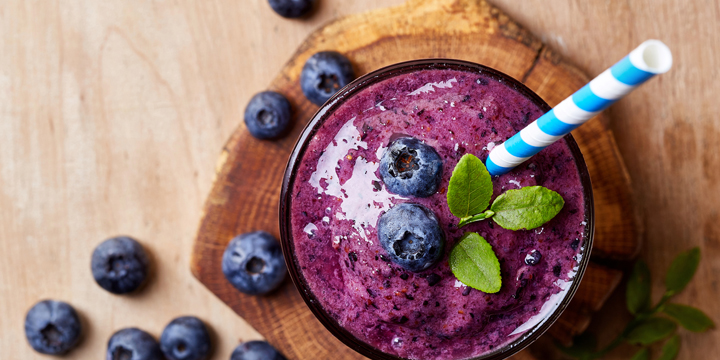 Glass of blueberry smoothie frozen fruit