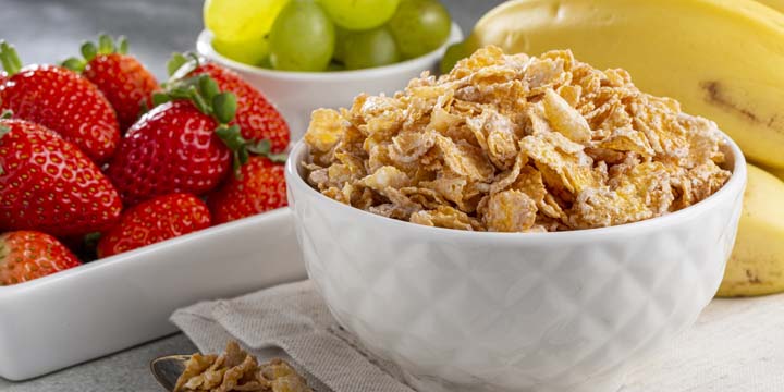 Corn flakes in the bowl with berries on the table. breakfast cereal