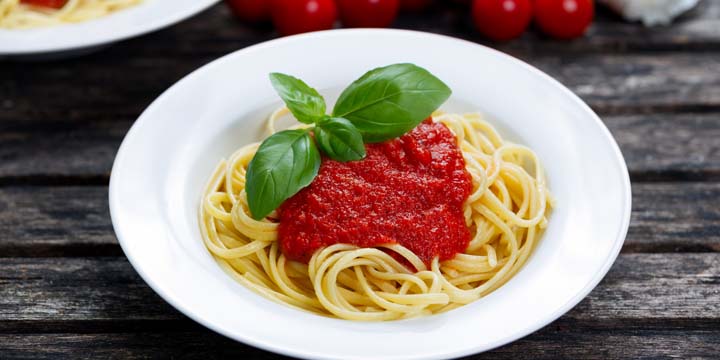 Spaghetti with marinara sauce and basil leaves on top. spaghetti sauce
